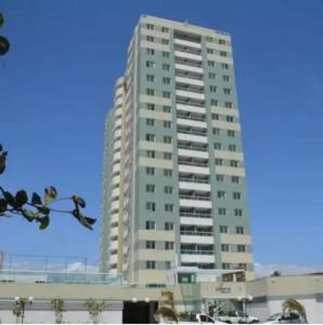 a tall white apartment building with a blue sky at Condomínio Solaris residencial Club in Ilhéus