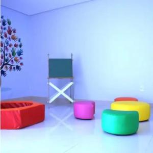 a room with four colorful tables and a chair at Condomínio Solaris residencial Club in Ilhéus