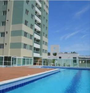 een groot gebouw met een zwembad voor een gebouw bij Condomínio Solaris residencial Club in Ilhéus