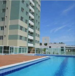 a large building with a swimming pool in front of a building at Condomínio Solaris residencial Club in Ilhéus