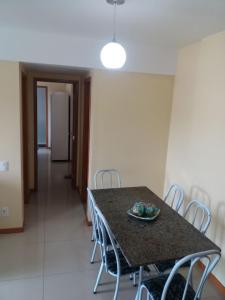 a dining room with a table and chairs at Condomínio Solaris residencial Club in Ilhéus