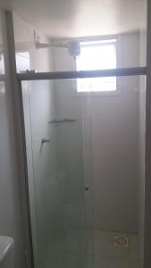 a shower with a glass door in a bathroom at Condomínio Solaris residencial Club in Ilhéus
