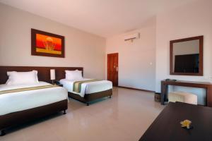 Postel nebo postele na pokoji v ubytování Adi Dharma Hotel Legian