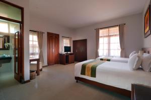 Postel nebo postele na pokoji v ubytování Adi Dharma Hotel Legian