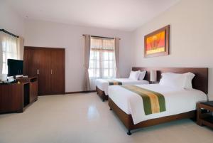 Postel nebo postele na pokoji v ubytování Adi Dharma Hotel Legian