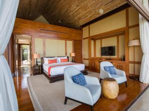 a bedroom with a bed and two chairs and a tv at Panacea Retreat in Bophut