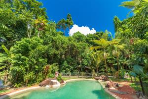 a pool at a resort with elephants in it at Safari Lodge in Cape Tribulation