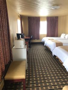 a hotel room with two beds and a desk at Travelodge by Wyndham Evanston in Evanston