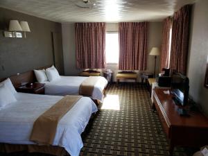 a hotel room with two beds and a television at Travelodge by Wyndham Evanston in Evanston