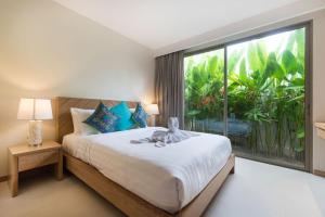 a bedroom with a bed with a large window at Trichada Tropical in Bang Tao Beach +70 photos