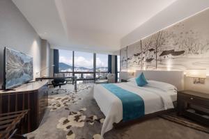 a bedroom with a bed and a desk and a television at Huaqiang Plaza Hotel Shenzhen, Enjoy Complimentary Mini Bar & Night Snack, Add breakfast - enjoy complimentary afternoon tea in Shenzhen