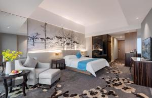 a bedroom with a bed and a living room at Huaqiang Plaza Hotel Shenzhen, Enjoy Complimentary Mini Bar & Night Snack, Add breakfast - enjoy complimentary afternoon tea in Shenzhen