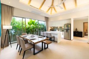 a dining room and kitchen with a table and chairs at Trichada Tropical in Bang Tao Beach