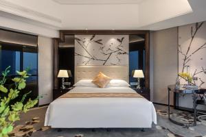 a bedroom with a large white bed and large windows at Huaqiang Plaza Hotel Shenzhen, Enjoy Complimentary Mini Bar & Night Snack, Add breakfast - enjoy complimentary afternoon tea in Shenzhen