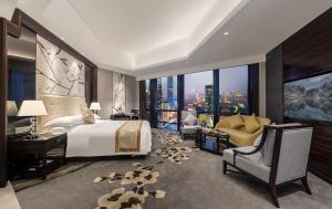 a bedroom with a large bed and a desk and a couch at Huaqiang Plaza Hotel Shenzhen, Enjoy Complimentary Mini Bar & Night Snack, Add breakfast - enjoy complimentary afternoon tea in Shenzhen