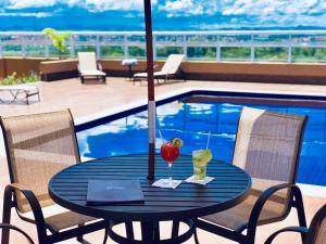 a black table with drinks on a patio with a pool at Lummina Mogi in Mogi Guaçu