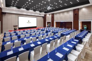 a conference room with blue and white chairs and a screen at Huaqiang Plaza Hotel Shenzhen, Enjoy Complimentary Mini Bar & Night Snack, Add breakfast - enjoy complimentary afternoon tea in Shenzhen