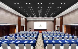 a conference room with blue and white chairs and a screen at Huaqiang Plaza Hotel Shenzhen, Enjoy Complimentary Mini Bar & Night Snack, Add breakfast - enjoy complimentary afternoon tea in Shenzhen