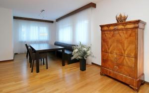 a dining room with a table and a wooden dresser at Chesa Alice in St. Moritz +12 photos