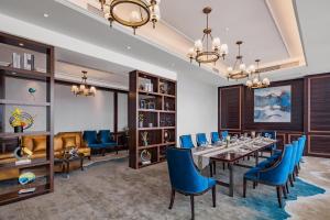 a dining room with a long table and blue chairs at Huaqiang Plaza Hotel Shenzhen, Enjoy Complimentary Mini Bar & Night Snack, Add breakfast - enjoy complimentary afternoon tea in Shenzhen