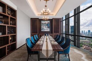 a long dining room with a long table and blue chairs at Huaqiang Plaza Hotel Shenzhen, Enjoy Complimentary Mini Bar & Night Snack, Add breakfast - enjoy complimentary afternoon tea in Shenzhen