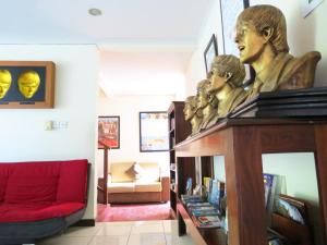 una sala de estar con un sofá rojo y estatuas sobre una mesa en Sekuta Condo Suites, en Sanur
