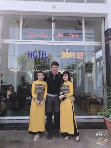Kon Tum (2)的住宿－洪邁酒店，一名男子和两名妇女站在旅馆前