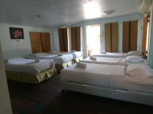 a group of four beds in a room at Prachuap Garden View Resort in Prachuap Khiri Khan