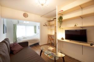 a living room with a couch and a flat screen tv at Roppongi ClassyHouse902 in Tokyo