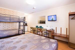 1 dormitorio con 1 cama, mesa y sillas en Augusta Budget Motel, en Port Augusta