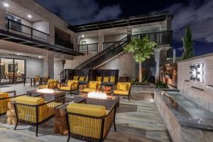 a patio with yellow chairs and tables and a fireplace at Bluestem Hotel Torrance Los Angeles, Ascend Hotel Collection in Torrance