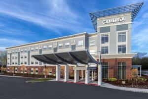 西奧蘭治的住宿－Cambria Hotel West Orange，一座白色的大建筑,上面有标志