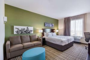 une chambre d'hôtel avec un lit et un canapé dans l'établissement Sleep Inn & Suites Yukon Oklahoma City, à Yukon