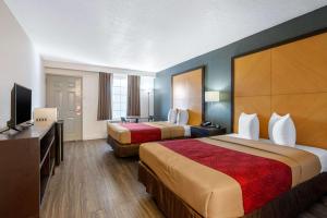 a hotel room with two beds and a flat screen tv at Econo Lodge Airport - RJ Stadium in Tampa