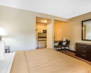 a hotel room with a large bed and a kitchen at Suburban Studios in Augusta