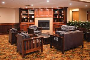 a lobby with chairs and a table and a fireplace at Quality Inn & Suites Ames Conference Center Near ISU Campus in Ames