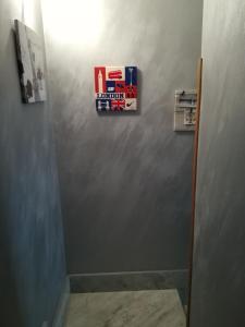 un bagno con un cartello su una parete grigia di City house a Campofelice di Roccella