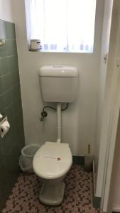 La salle de bains est pourvue de toilettes blanches et d'une fenêtre. dans l'établissement Aquatic Motor Inn, à Taree