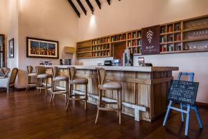 un bar con una fila de taburetes en un restaurante en Anasa Wellness Resort, en Ella