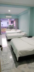a group of four beds in a room at JS Guest House Air Putih - Roomstay in Kuantan