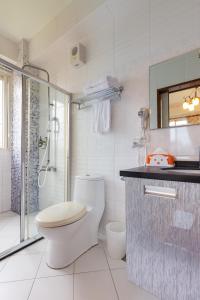 a white bathroom with a toilet and a shower at 花蓮統一的家民宿The home place in Ji'an