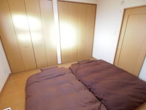 um pequeno quarto com uma cama grande em 岡崎Haus em Okazaki