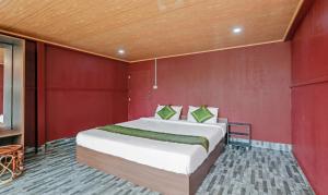 a bedroom with a bed in a red wall at Itsy By Treebo - Jammabane Cottage With Mountain View in Madikeri