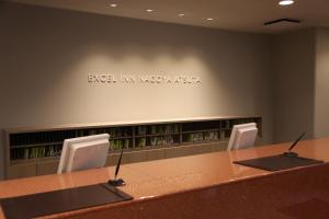 una sala conferenze con tavolo, sedie e biblioteca di Excel Inn Nagoya Atsuta a Nagoya