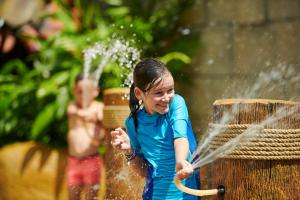 a young girl playing with a water hose at PARKROYAL Penang Resort in Batu Ferringhi