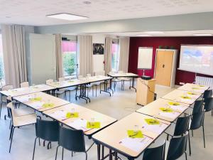 a classroom with tables and chairs and a projection screen at Brit Hotel Mayenne in Mayenne