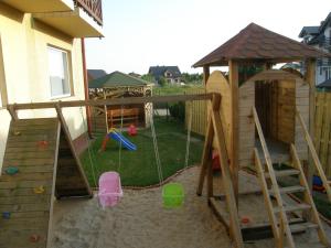 einen Hinterhof mit Spielplatz mit Spielset in der Unterkunft Szaman Morski in Jastrzębia Góra