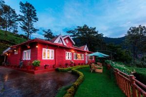 een rood huis met een hek ervoor bij Teanest by Nature Resorts in Coonoor