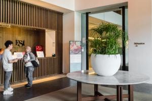 a woman standing next to a table with a potted plant at EST Suites Bangsar by Airhost in Kuala Lumpur
