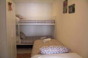 een kleine slaapkamer met een bed en een stapelbed bij Casa MENDILUCE in El Pueyo de Jaca